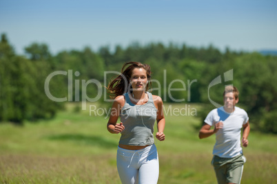 Young couple jogging outdoors in spring nature