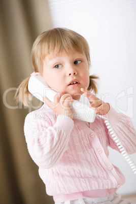 Little girl holding telephone receiver calling