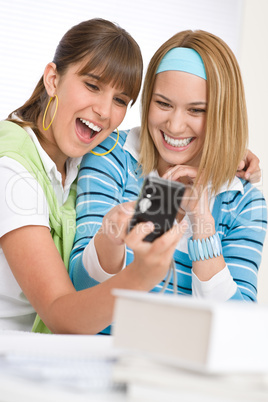 Two young cheerful woman with camera