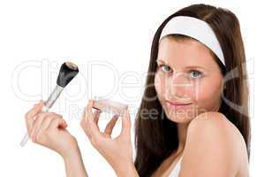 Beautiful woman applying powder with brush