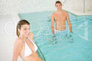 Young couple relax in swimming pool, focus on woman