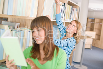 Student in library - two woman choose book