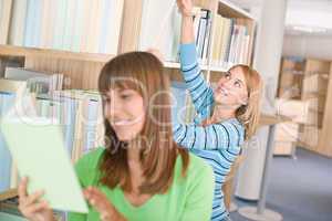 Student in library - two woman choose book