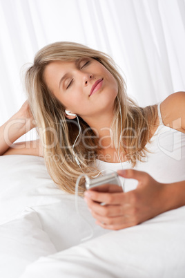 White lounge - Young woman enjoying music with ear buds