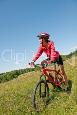 Young woman with mountain bike in spring nature