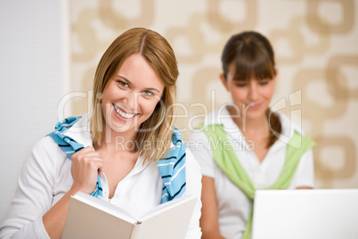 Student at home - two woman with book and laptop