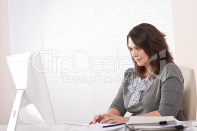 Young business woman working with computer at office