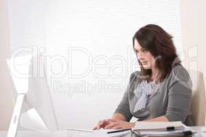 Young business woman working with computer at office