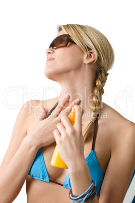 Beach - Young woman in bikini apply suntan lotion