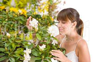 Portrait of woman smelling blossom of Rhododendron flower