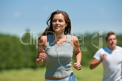 Young couple jogging outdoors in spring nature