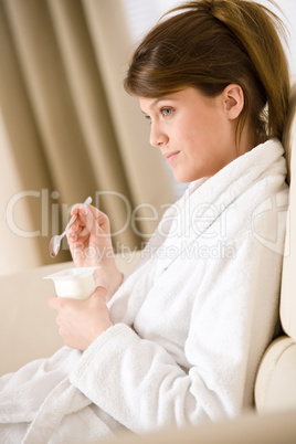 Young woman eat yogurt for breakfast