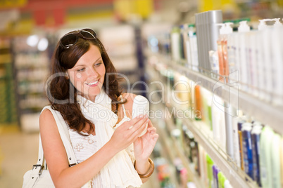 Shopping cosmetics- smiling woman holding shampoo