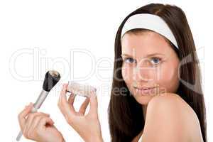 Beautiful woman applying powder with brush