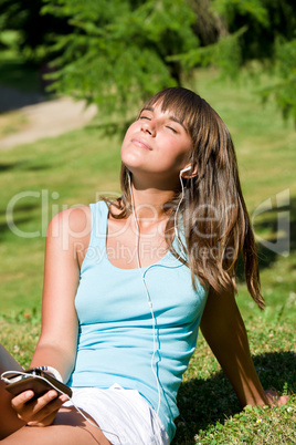 Young woman listen to music in park