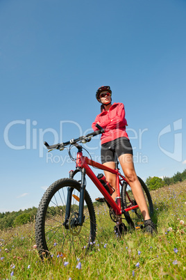 Young woman with mountain bike in spring nature