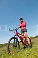 Young woman with mountain bike in spring nature