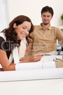 Smiling man and woman with architectural model