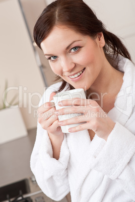 Young woman enjoying cup of coffee in kitchen