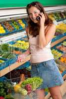 Grocery store shopping - Smiling woman with mobile phone