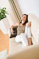 Young happy woman relax lying down on sofa