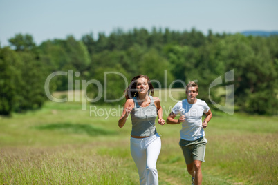 Young couple jogging outdoors in spring nature