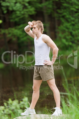 Sportive man stretching after training in nature