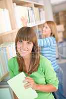 Student in library - two woman hold book