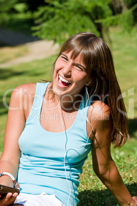 Young woman listen to music in park