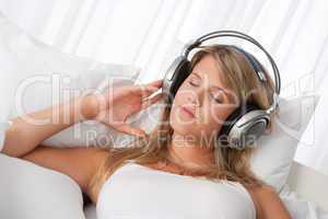 White lounge - Blond woman with headphones listening to music