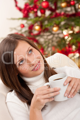 Woman with coffee in front of Christmas tree