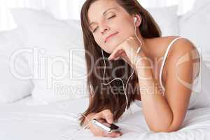 Young woman listening to music holding mp3 player
