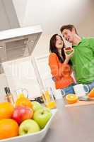 Young man and woman eating toast in the kitchen