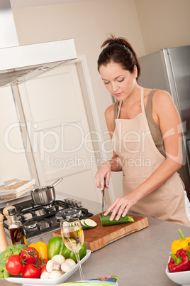 Young woman cutting zucchini in the kitchen