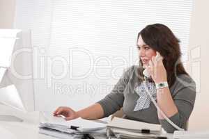 Attractive executive woman on phone at office