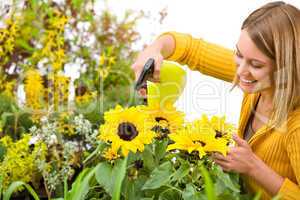 Gardening - woman sprinkling water to sunflowers