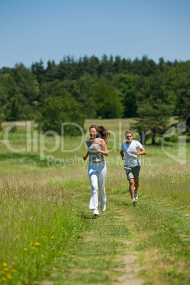 Young couple jogging outdoors in spring nature