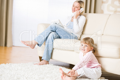 Mother and child in living room watch television