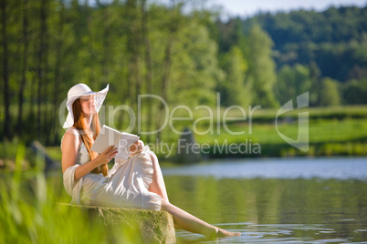 Long red hair romantic woman relax by lake with book