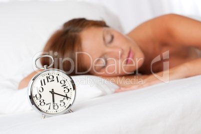 White lounge - Sleeping woman in bed with alarm clock