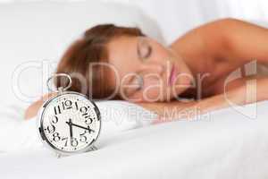 White lounge - Sleeping woman in bed with alarm clock