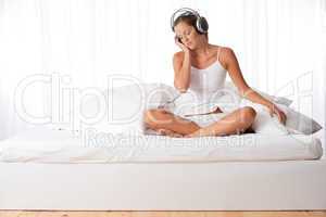 Young woman in white with headphones