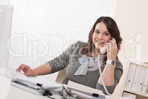 Smiling young woman on the phone at office