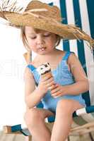 Beach - Little girl on deck-chair with hat and ice-cream