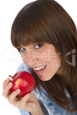 Happy teenager in pajamas eating healthy apple