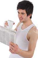 Morning - young man with coffee and newspaper