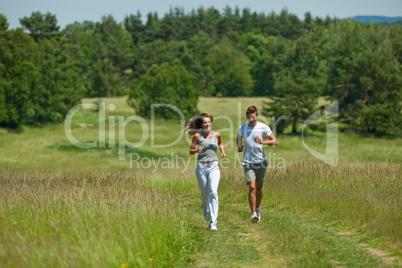 Young couple jogging outdoors in spring nature