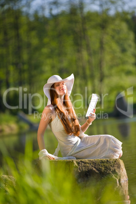 Long red hair romantic woman relax by lake with book