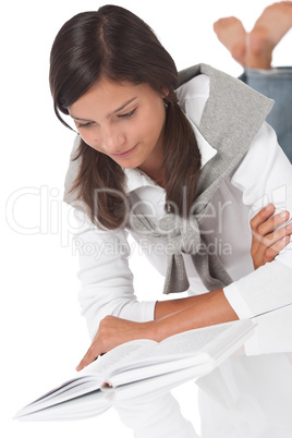 Teenager lying and reading book