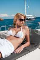 Blond woman sunbathing in bikini on luxury yacht